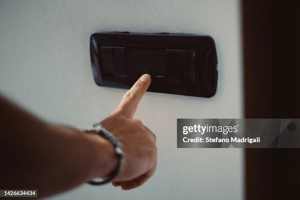 the hand closes the light switch - light switch stock pictures, royalty-free photos & images