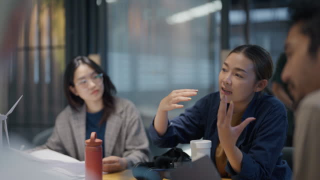 두 명의 아시아 여성과 팀이 지속 가능한 혁신 프로젝트를 진행하고 있습니다.