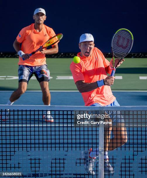 Andre Goransson of Sweden shots a backhand with partner Ben McLachlan of Japan looking on as they compete against Tomas Etcheverry of Argentina and...