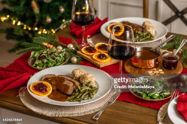 dîner de noël rôti de bœuf venaison avec sauce et canneberges dans la cuisine rustique maison - rosbif photos et images de collection