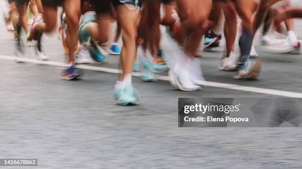 low section unknown people running marathon, defocused sports background - triathlon stockfoto's en -beelden