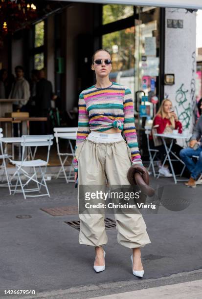 Guest wears knotted striped jumper, boxer shorts, beige pants, brown bag outside Missoni during the Milan Fashion Week - Womenswear Spring/Summer...