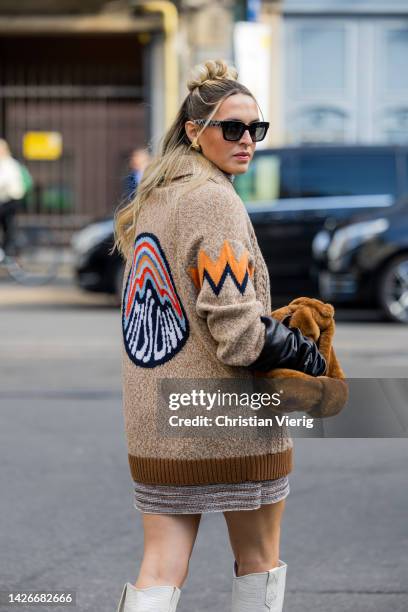 Camila Carril wears brown cardigan, brown teddy bag, boots, striped dress, black gloves outside Missoni during the Milan Fashion Week - Womenswear...