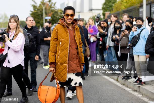 Tamu Mcpherson is seen wearing a quilted brown coat, large orange Tod's bag and cow print skirt at Tod's show during the Milan Fashion Week -...