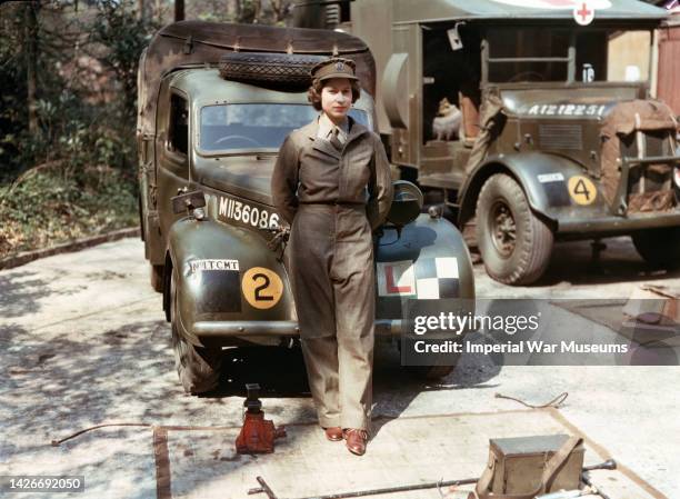 Princess Elizabeth, a 2nd Subaltern in the Auxiliary Territorial Service, standing in front of an L-plated truck, with a medical lorry in the...