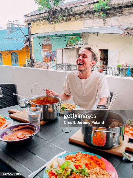 handsome caucasian young man laughing during a dinner party food tour in panama city, panama - panama stock pictures, royalty-free photos & images