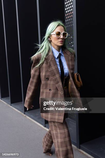 Tina Leung is seen wearing and oversized checkered jacket and high waisted pants, a large belt, bleu shirt and black tie at Gucci show during the...