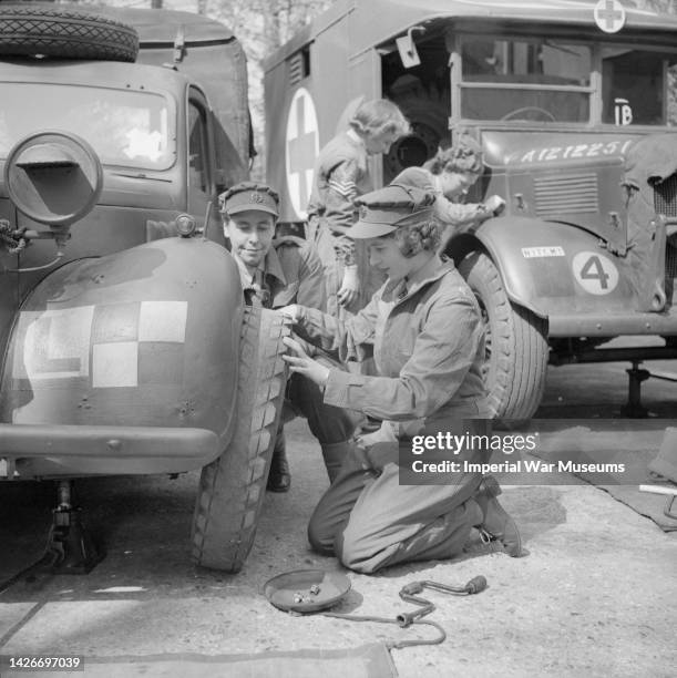 At a Vehicle Maintenance Class, Princess Elizabeth wearing overalls changes the wheel of a car, Auxiliary Territorial Service Training Centre,...