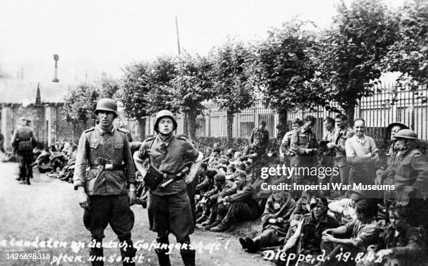 Allied prisoners rest by the roadside, guarded by Germans, Dieppe, 19th August 1942.