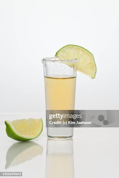 tequila shot with lime slices. - tequila stock-fotos und bilder