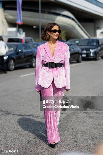 Tamara Kalinic wears black belt pink oversized blazer, pants, black heart shaped bag outside Etro during the Milan Fashion Week - Womenswear...