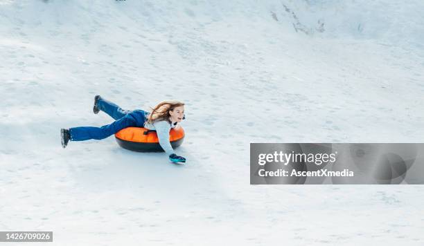 une jeune fille glisse sur une pente de neige sur un tube de neige - flagstaff photos et images de collection