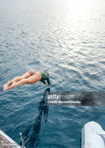 joven se sumerge en el mar desde barco - just do it fotografías e imágenes de stock