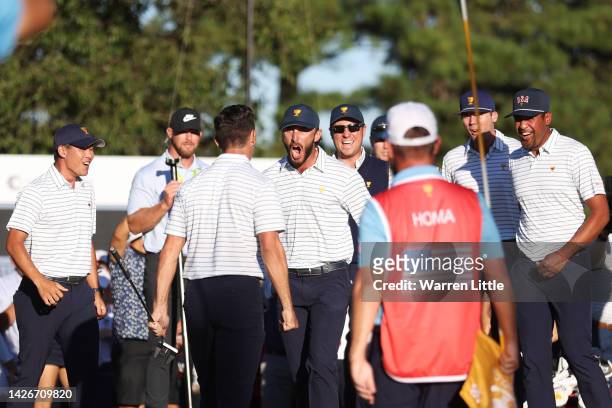 Max Homa of the United States Team celebrates with teammate Billy Horschel after making his putt on the 18th green to win 1 Up against Corey Conners...