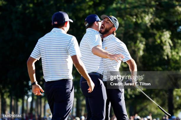 Max Homa of the United States Team celebrates with Sam Burns and Collin Morikawa after making his putt on the 18th green to win with teammate Billy...