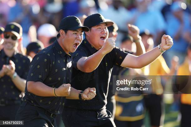 Tom Kim of South Korea and the International Team and Sungjae Im of South Korea and the International Team react to a putt on the 18th green by an...