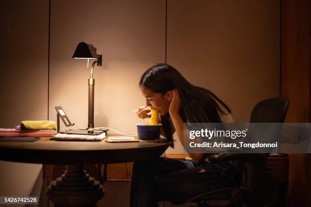 woman eats instant noodles - instant noodles stock pictures, royalty-free photos & images