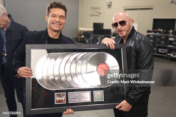 Ryan Seacrest and Pitbull pose with an award during the 2022 iHeartRadio Music Festival at T-Mobile Arena on September 23, 2022 in Las Vegas, Nevada.