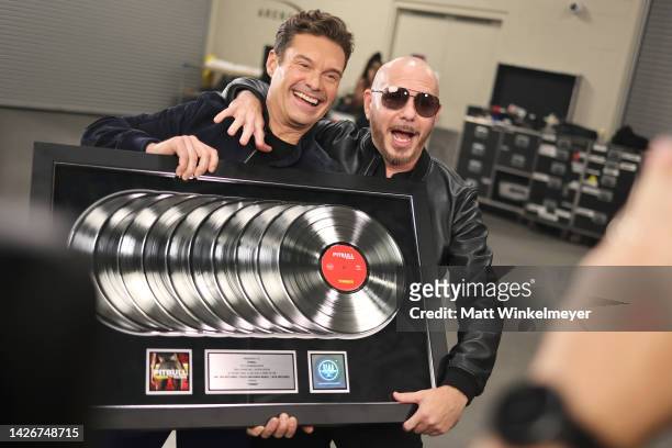 Ryan Seacrest and Pitbull pose with an award during the 2022 iHeartRadio Music Festival at T-Mobile Arena on September 23, 2022 in Las Vegas, Nevada.