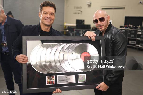 Ryan Seacrest and Pitbull pose with an award during the 2022 iHeartRadio Music Festival at T-Mobile Arena on September 23, 2022 in Las Vegas, Nevada.