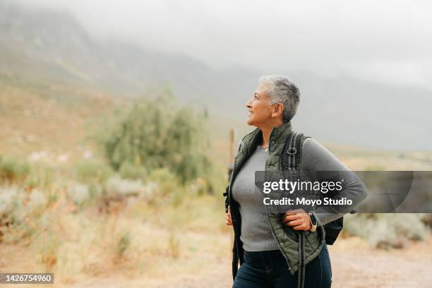Mature woman hiking, scenic nature views and freedom, travel and adventure in peace, calm and cloudy morning hike outdoor. Happy, fresh and smile lady, tourist and traveler in mountains environment