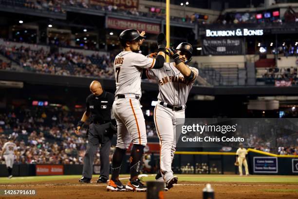 David Villar high fives J.D. Davis of the San Francisco Giants after hitting a two-run home run during the fourth inning against the Arizona...