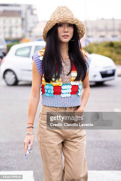 Yoyo Cao is seen wearing a multicolor sweater, beige pants and straw hat outside the Tod's show during the Milan Fashion Week - Womenswear...