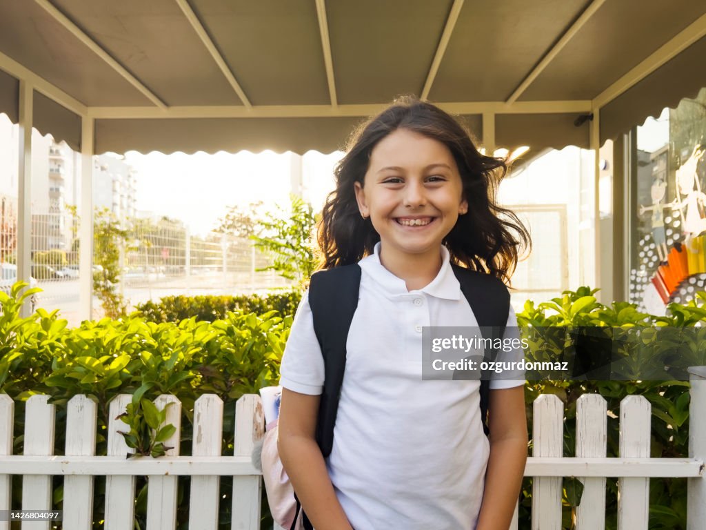 Portrait of a young student girl smiling outside the school