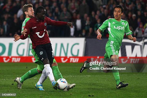 Didier Ya Konan of Hannover scores the second goal against Marco Russ of Wolfsburg and Makoto Hasebe of Wolfsburg during the Bundesliga match between...