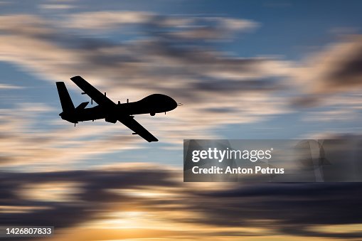 Military unmanned aerial vehicle at sunset. Combat drone in military conflicts Military unmanned aerial vehicle at sunset. Combat drone in military conflicts