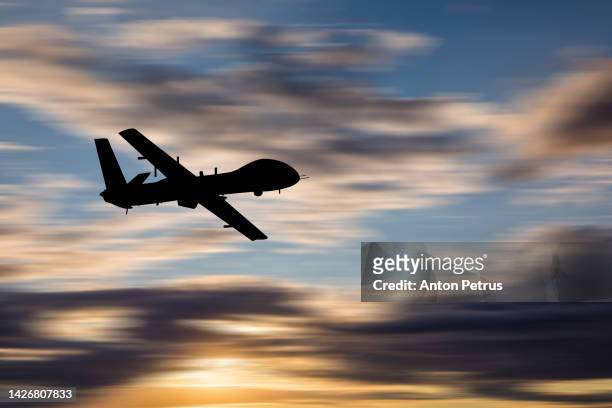 military unmanned aerial vehicle at sunset. combat drone in military conflicts - luchtaanval stockfoto's en -beelden