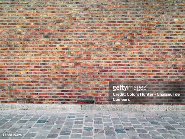 empty brown brick wall and gray cobblestone sidewalk in brussels, belgium - cobblestone texture stock pictures, royalty-free photos & images