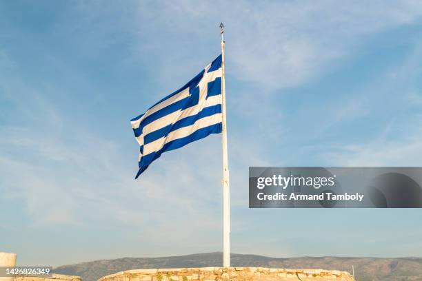 flag of greece against blue sky - greek flag stock pictures, royalty-free photos & images