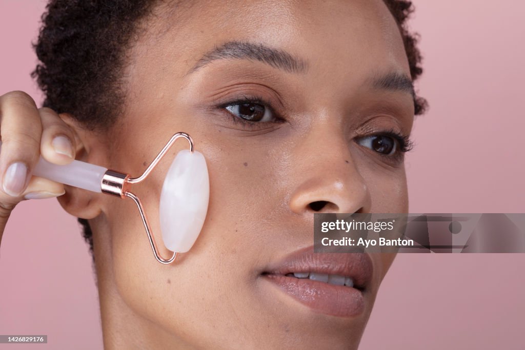 Close-up of woman using facial roller