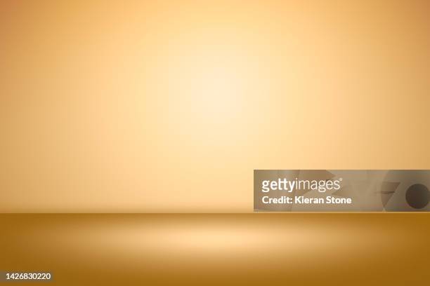 simple gold studio back drop - backgrounds stock pictures, royalty-free photos & images