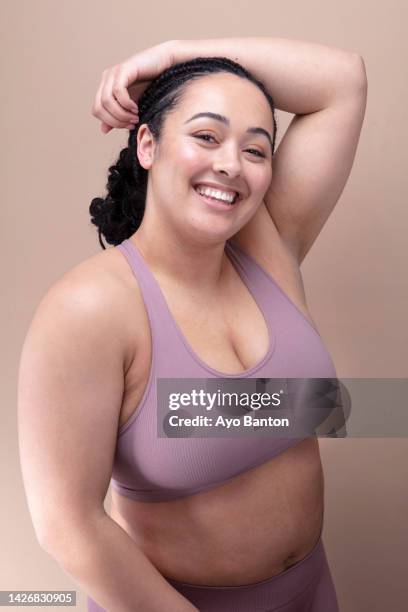 studio portrait of smiling woman in purple bra - femme décolleté photos et images de collection