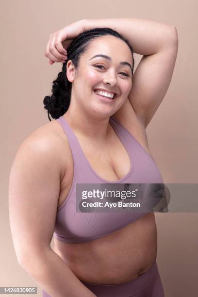 studio portrait of smiling woman in purple bra - reveiling stock pictures, royalty-free photos & images