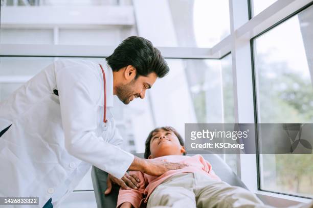the doctor examines the patient on the table - doctor lab coat stockfoto's en -beelden