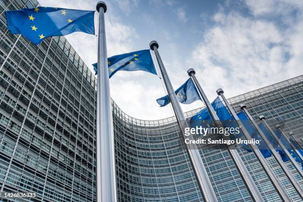european union flags waiving at berlaymont building of the european commission - quartier européen bruxelles photos et images de collection
