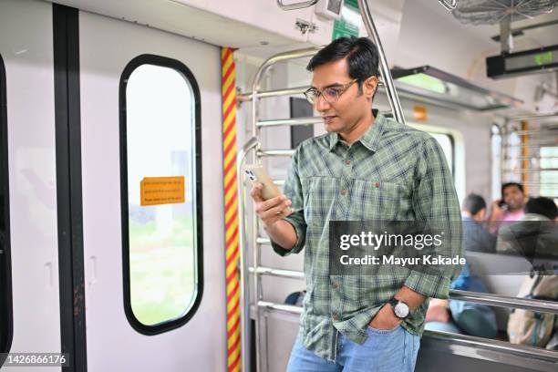 man using smart phone in train - mumbai daily life stock pictures, royalty-free photos & images