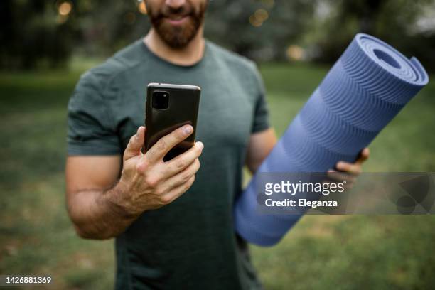 close up of sporty young man using phone and preparing for workout - sprint phone stock pictures, royalty-free photos & images