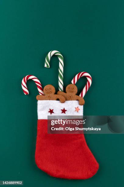 christmas sock with candy canes on a green background with copy space. - candy cane stock pictures, royalty-free photos & images