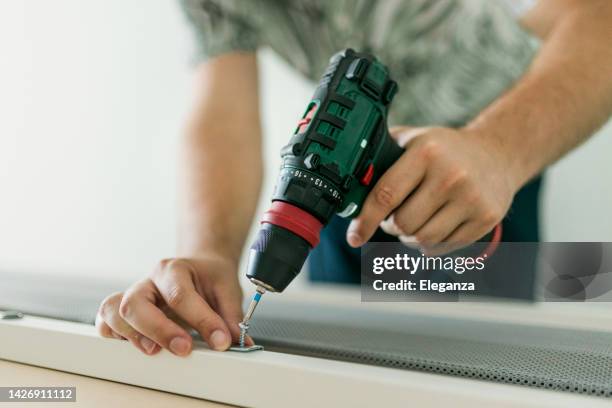 close up of man doing renovation work at home - drill stock pictures, royalty-free photos & images
