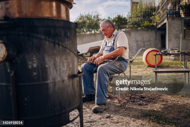 grandpa is making brandy - brewmaster stockfoto's en -beelden