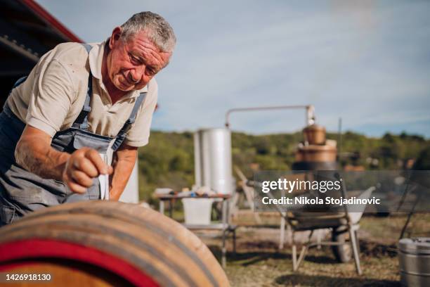 mature man distills brandy - vodka stock pictures, royalty-free photos & images