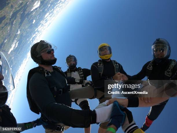 skydivers fall upside down, in aerial flight - skydiving team stock pictures, royalty-free photos & images