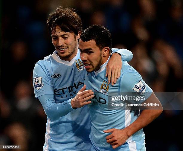 Carlos Tevez of Manchester City celebrates scoring his team's third goal with team mate David Silva during the Barclays Premier League match between...