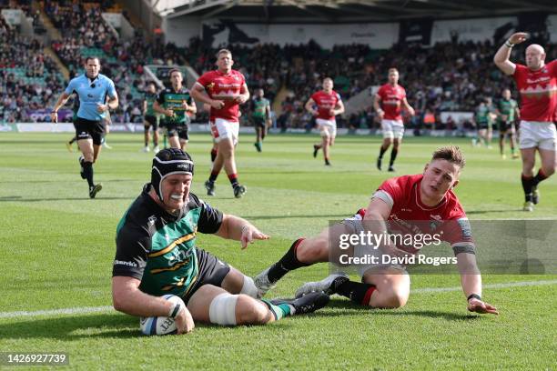 Alex Coles of Northampton Saints scores their side's third try after fending off Freddie Steward of Leicester Tigers during the Gallagher Premiership...