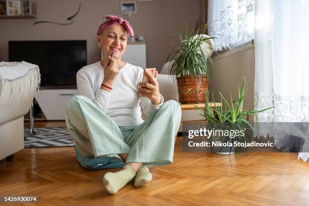 mulher aplica maquiagem após quimioterapia - leukemia - fotografias e filmes do acervo