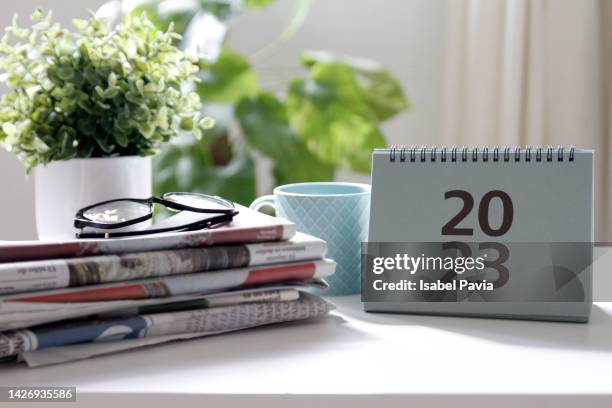 2023 calendar and newspapers on desk - calendario fotografías e imágenes de stock